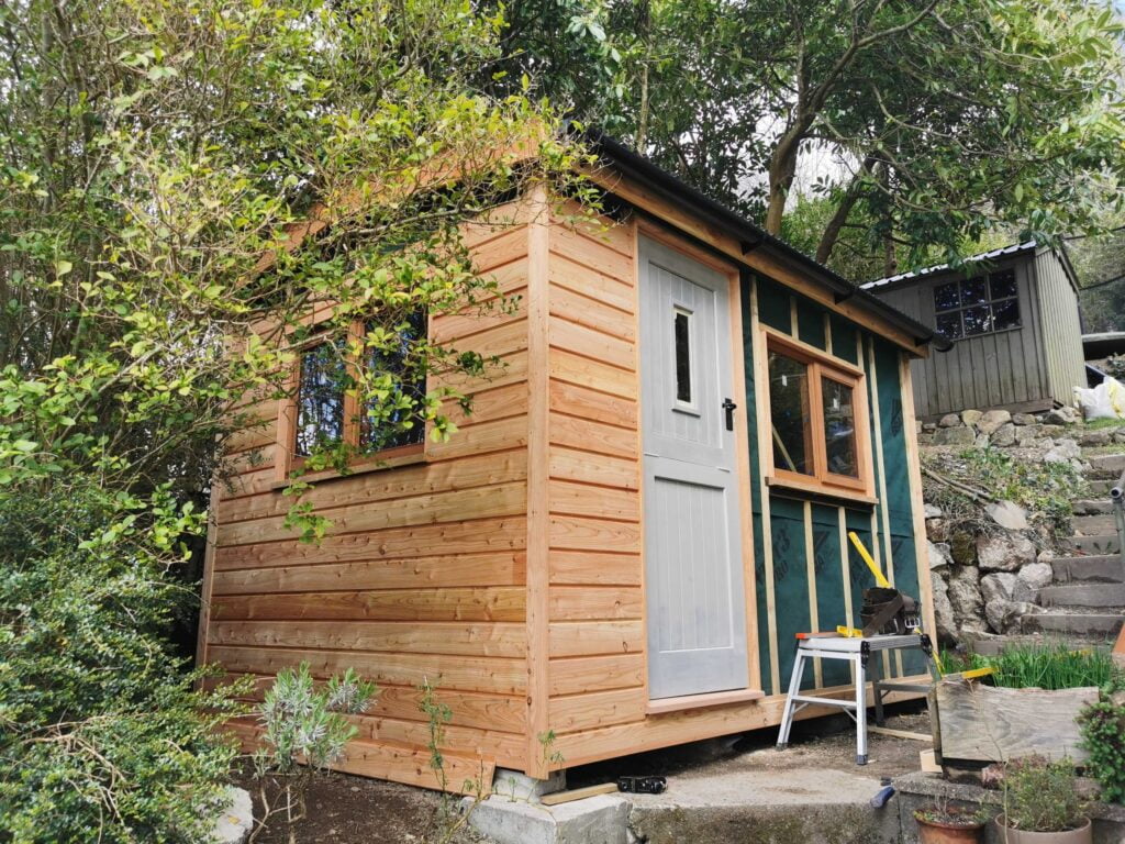 Green larch cladding is going on the walls